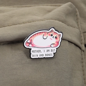 Detailed enamel pin of a fat cat with 'Mother, I am but skin and bones' text on fabric