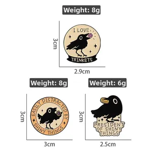 Detail of raven enamel pins featuring witty phrases and shiny gold ring accents