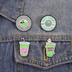 Cute matcha themed enamel pin set on denim jacket with creative drink bottle designs