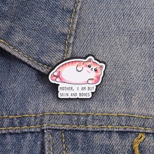 Funny fat cat enamel pin on blue denim jacket with Mother I am but skin and bones text