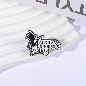 Dark fantasy enamel pin with dragons and faeries text on a white wave display background