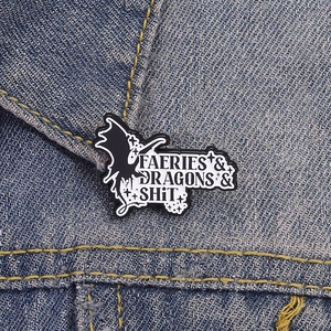 Cartoon enamel pin with Faeries & Dragons & Shit slogan on denim jacket collar
