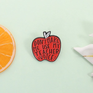 Enamel apple pin featuring 'Don't make me use my teacher voice' text for educators
