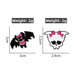 Detail view of cartoon bat and skull enamel pins showing dimensions and 2g weight specs