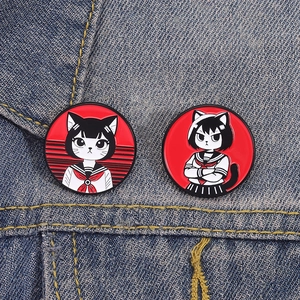 Détail de pins en émail animé avec fille chat en costume marin sur veste en denim