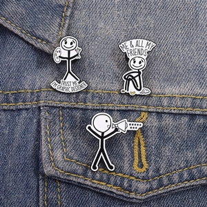 Set of three funny stickman enamel pins on a denim jacket with graphic designer text