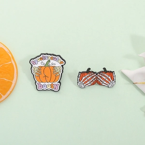 Funny Halloween enamel pins featuring pumpkin and skeleton hand with Spooktacular booty text