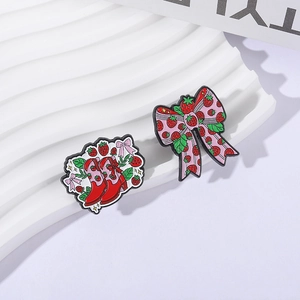 Ensemble de broches en émail nœud fraise et bottes rouges sur support de présentation