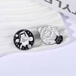 Broches en émail chat de l'espace noir et blanc sur un plateau blanc artistique
