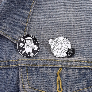 Lot de deux pins chat de l'espace en émail noir et blanc sur tissu en jean