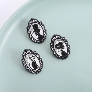 Gothic skull cat and figure pins in vintage frame designs on a porcelain plate