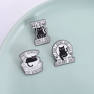 Tre creative spille in smalto gatto nero con scritte divertenti su un piatto
