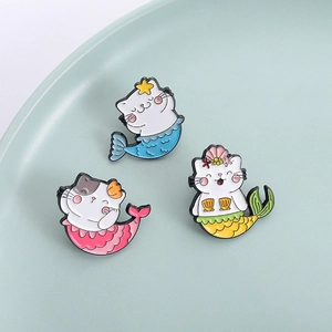 Trois pin's mignons chat-sirène émaillés en bleu, rose et jaune avec détails