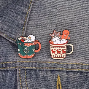 Christmas enamel pins set with snowman and reindeer cup designs on denim fabric