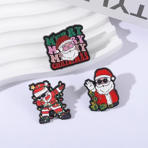 Set di tre spille natalizie in smalto con distintivi di Babbo Natale su espositore a onde