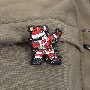 Detail of dabbing Santa enamel pin with sunglasses and colorful lights on canvas