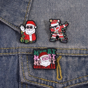 Trois pin's créatifs de Noël en émail avec le Père Noël et des textes de fête joyeux