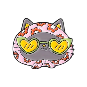 Dettaglio della spilla a gatto in smalto con foulard rosa e occhiali da sole verdi