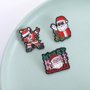 Three-piece set of Christmas Santa enamel pins featuring DAB pose and holiday greetings