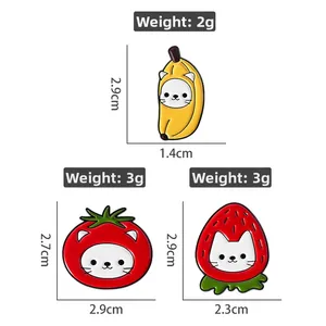 Detailed view of banana, tomato, and strawberry cat enamel pins with size and weight