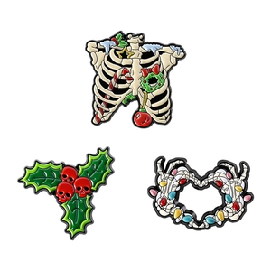 Three-piece Christmas skull enamel pins with candy canes, wreaths, and festive lights
