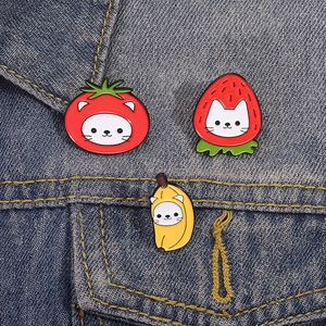 Cute fruit cat enamel pins set featuring strawberry banana tomato designs on denim jacket