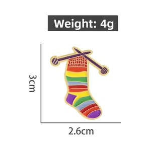 Detail view of rainbow knit sock enamel pin with knitting needles and dimensions