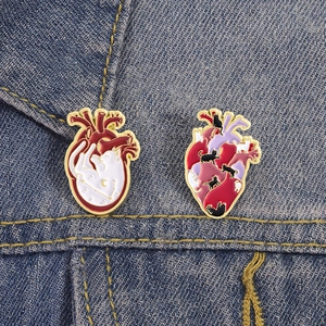 Gros plan de broches en forme de cœur avec motifs de chats sur veste en jean