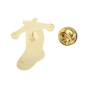 Macro detail of the golden metal brooch back with sandblasted finish and butterfly clasp