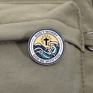 Détail de broche émaillée ronde avec croix et montagne sur tissu en toile olive
