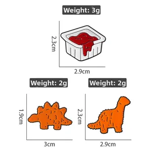 Detail view of sauce cup and dinosaur-shaped chicken nugget enamel pins with dimensions