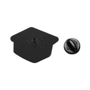 Macro detail of dinosaur enamel pin back with matte texture and black rubber clutch backings