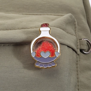 Broche émaillée fiole de potion magique avec paillettes sur un sac à dos