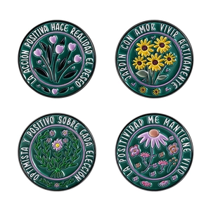 Set of four green enamel flower pins featuring sunflower and tulip with Spanish quotes