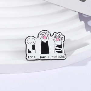 Cute cat paw enamel pins featuring rock paper scissors game on a white wavy pedestal