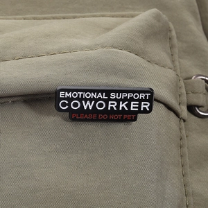 Nahaufnahme der rechteckigen Emaille-Anstecknadel mit Emotional Support Coworker Text