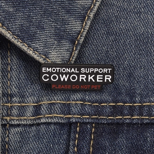 Makroaufnahme von Emotional Support Coworker Emaille-Pin auf einer Denim-Jacke