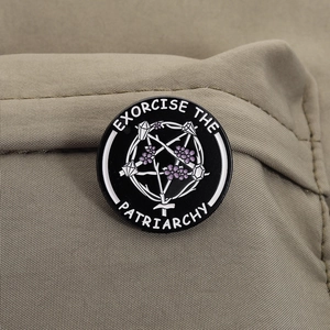 Détail de la broche ronde en émail avec slogan Exorcise The Patriarchy et étoile gothique