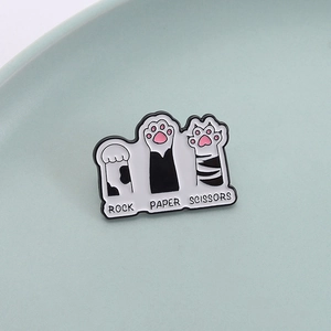 Cute cat paw enamel pin set featuring rock paper scissors game on light teal background