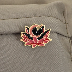 Détail de la broche lotus étoilé avec lune et étoiles sur texture de tissu brun