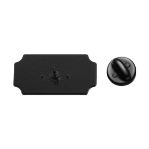 Détail du dos de badge en métal noir mat avec attache papillon sécurisée
