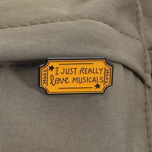Détail macro du pin's émaillé vintage I Just Really Love Musicals en forme de ticket