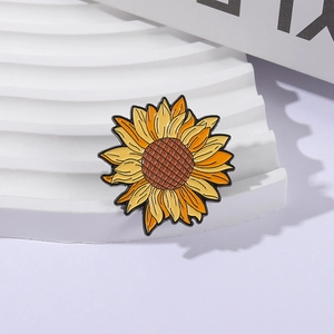 Charming sunflower enamel brooch with yellow petals on a white tiered display stand