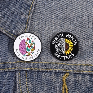 Close-up of Mental Health and Neurodiversity pins on a blue denim jacket