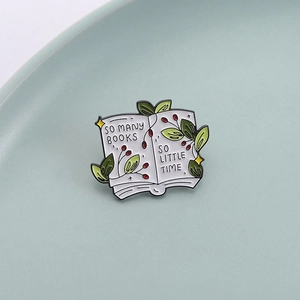 Literary book enamel pin with green plants and 'So Many Books' text on a ceramic plate
