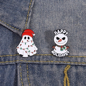 Detail of Christmas ghost and snowman enamel pins on blue denim jacket fabric
