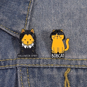 Détail de pin's chat d'Halloween en émail sur denim avec texte Halloween Spirit et Bobcat