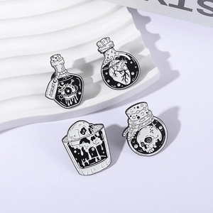 Set of four gothic enamel pins featuring eye, heart, and skull in laboratory bottles