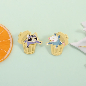 Cartoon raccoon and opossum in trash can enamel pins on a fresh green background