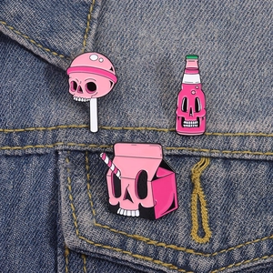 Detailopname van roze schedel emaille speldjes op denim stof voor kleding decoratie